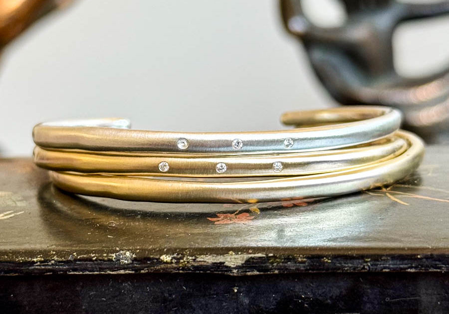 Sterling silver and gold organic cuff bracelets with small diamonds stacked together