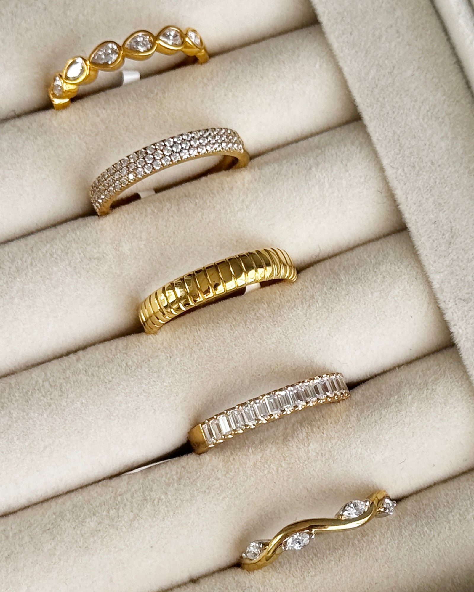 Gold and diamond rings displayed in a velvet jewelry tray close-up