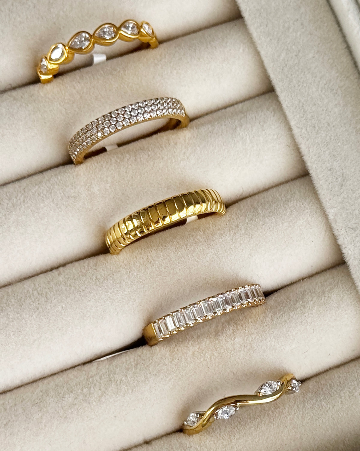 Gold and diamond rings displayed in a velvet jewelry tray close-up