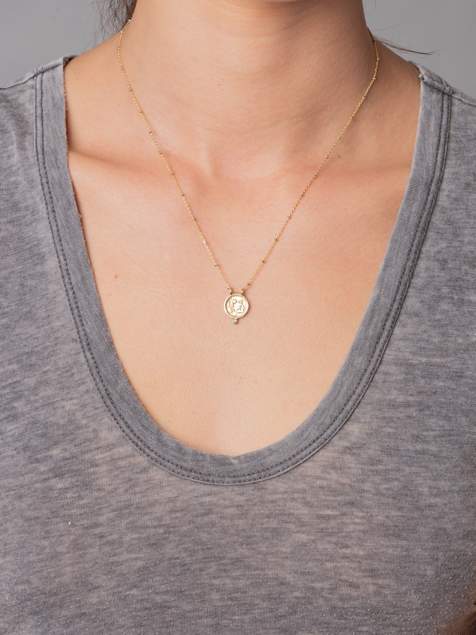 Pisces Necklace in yellow bronze with blue diamond by Lulu Designs.